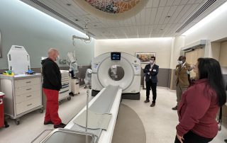 county supervisor Lena Tam at San Leandro Hospital with AHS staff and AHS CEO looking at CT Scan machine.
